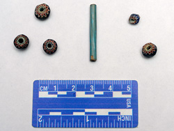 Glass trade beads found at the Luna settlement, including five seven-layer faceted chevron beads, and one tubular Nueva Cadiz Twisted bead, with scale.